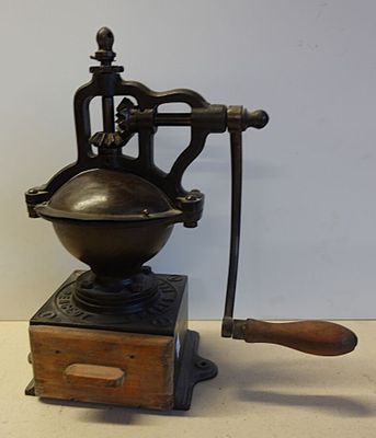 un moulin à café posé sur une table à côté d'une boîte en bois