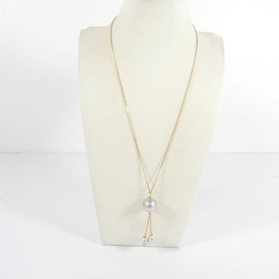 un mannequin blanc portant une chaîne en or et un pendentif en perle