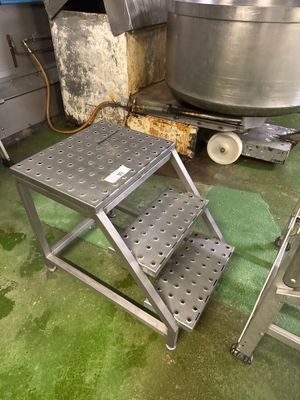 un tabouret métallique au milieu d'un sol vert
