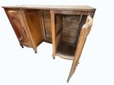 a wooden cabinet with a door open and a chair in front of it