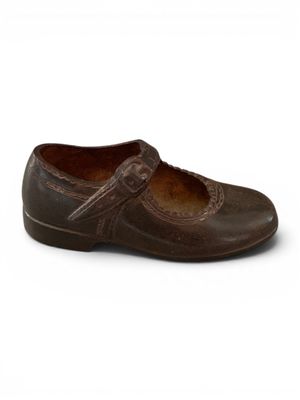 chaussures de type « clogger » en cuir marron, avec des lanières et des boucles, sur fond blanc