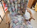 a chair with a floral upholstered seat in the middle of a room
