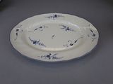 a white plate with blue flowers on it sitting on a table