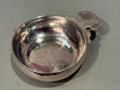 a silver bowl with a spoon in it on a table