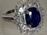 une image d'une bague avec une pierre bleue entourée de diamants