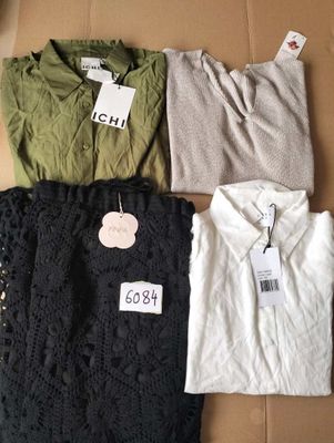 three shirts are sitting on a cardboard box with tags on them