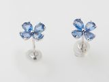 une paire de boucles d'oreilles en forme de fleur en saphir bleu sur fond blanc