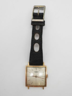 l'image d'une montre en or avec un bracelet en cuir noir