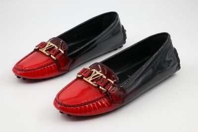deux paires de mocassins rouges et noirs ornés d'une boucle dorée