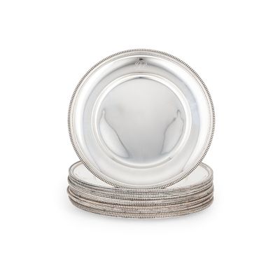 une image représentant une assiette en argent posée sur une pile d'assiettes en argent