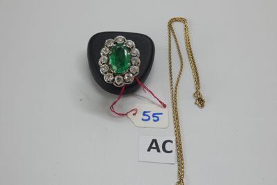 un gros plan sur un collier orné d'une pierre verte et d'une chaîne en or