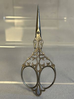 une paire de ciseaux posée sur une table devant une vitrine