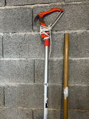 a shovel and a stick on the ground next to a brick wall