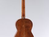 a wooden guitar hanging from a string on a white background
