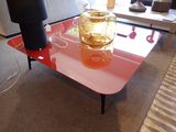 une table en verre sur laquelle se trouve un vase, dans un salon