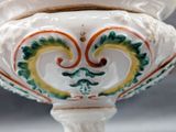 a white vase with a green and yellow design on it