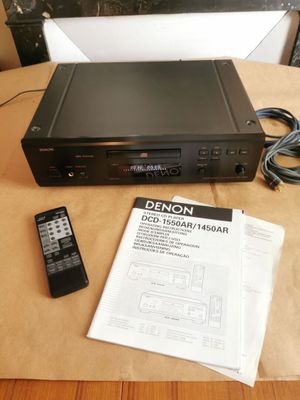 un lecteur DVD posé sur une table, avec une télécommande à côté
