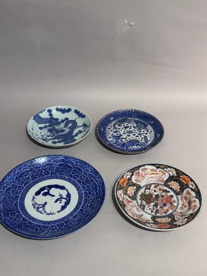 four blue and white plates sitting on top of a table