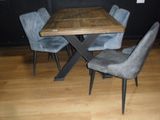 une table en bois entourée de chaises dans une pièce