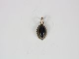 a silver and black stone pendant on a white surface