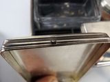 a person holding a silver box with a silver object inside of it