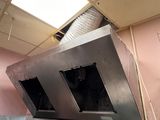 une photo d'une cuisine avec une cuisinière au milieu de la pièce