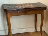a small wooden table with a checkerboard top on it