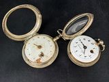 three different types of pocket watches on a black surface