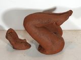 une sculpture en argile représentant un oiseau et une chaussure posée sur une table