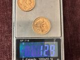 une petite balance sur laquelle repose une pièce de monnaie et une calculatrice posée sur la table