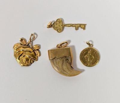 trois bijoux en or, dont une clé, une pièce de monnaie et un pendentif