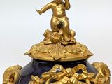 a gold and blue clock with a statue on top of it