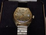 a gold watch sitting in a box on a black surface