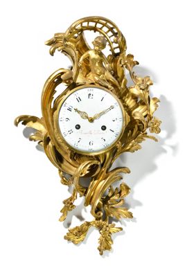 une horloge dorée posée sur une surface blanche