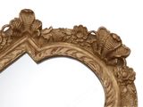 a mirror with a gold frame and a bird on it