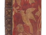 un vieux livre avec un oiseau et des fleurs sur la couverture
