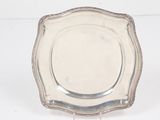 un plateau d'argent antique sur un support sur fond blanc