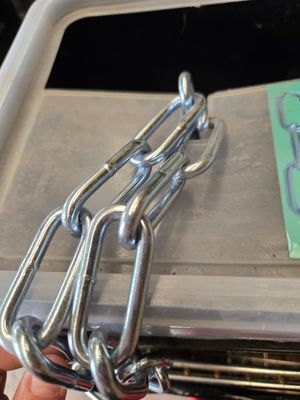 une personne tenant un faisceau de chaînes métalliques dans la main