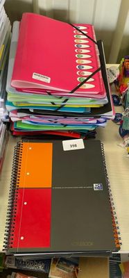 une pile de livres posée sur un bureau, à côté d'une autre pile de livres