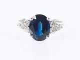a close up of a blue sapphire and diamond ring on a white background