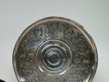 a silver plate with a spoon and a spoon rest on a table