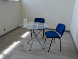 une table et deux chaises dans une pièce dotée d'une fenêtre