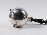 a silver ball with a black handle on a white surface