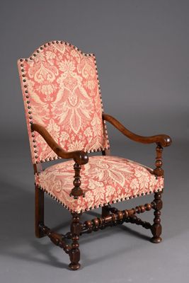 une vieille chaise dont le dossier est recouvert de tissu rose et blanc