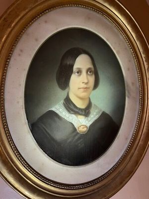 une photo d'une femme en robe noire, dans un cadre doré