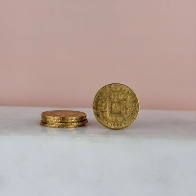 deux pièces d'or posées sur un plan de travail en marbre