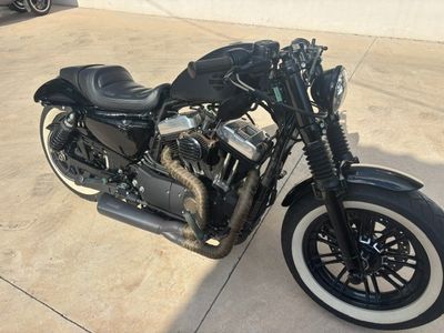 a black motorcycle parked in a parking lot next to a building