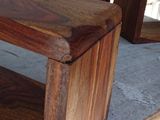 two wooden benches sitting on a cement floor