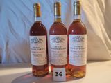 trois bouteilles de vin posées sur une table l'une à côté de l'autre