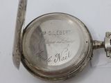 a silver pocket watch that is on a white surface